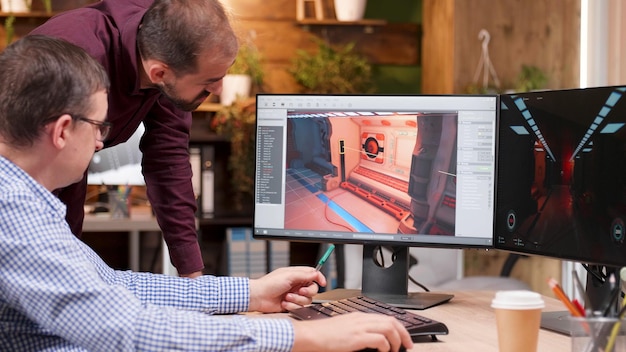 Designer gráfico na indústria de jogos falando em detalhes com seu colega, analisando o nível de design 3D, explicando ideias criativas de produção. Criadores de jogos trabalhando em ilustração de videogame no escritório da empresa