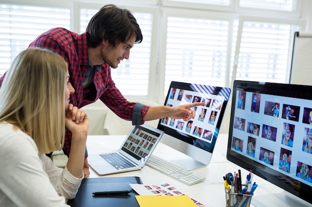 Foto grátis designers gráficos masculinos e femininos interagindo sobre o computador