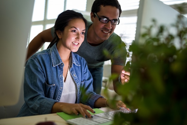 designers gráficos masculinos e femininos que trabalham no computador