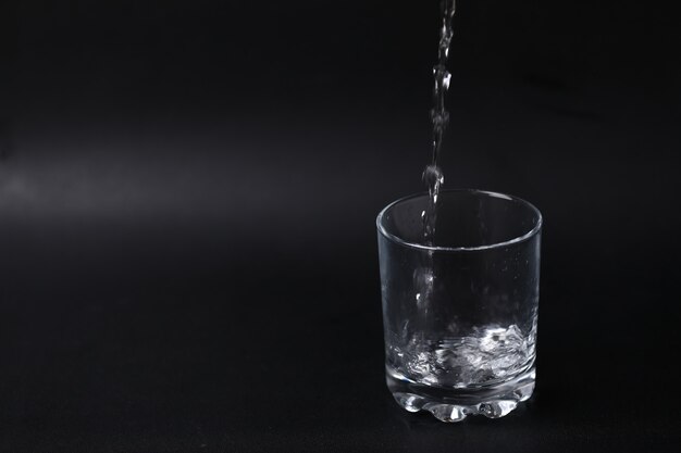 Despejando água em um copo vazio.