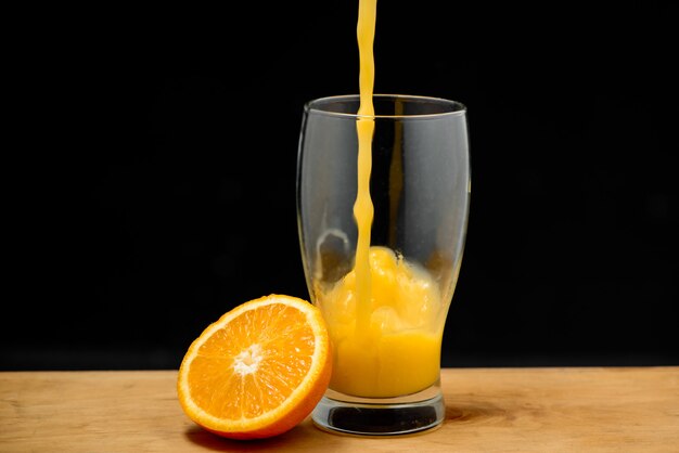 Despejando suco de laranja em vidro Copie o espaço