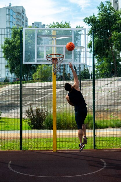 Desportista, marcando um gol na cesta de basquete