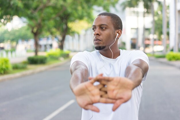 Desportista preta séria que aquece as mãos antes de treinar.