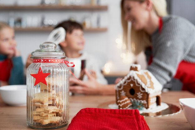 Detalhe de biscoitos de gengibre e família na cozinha