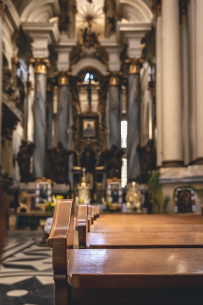 Detalhes interiores de uma igreja católica com bancos de madeira