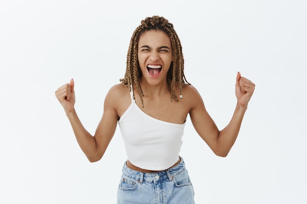 Foto grátis determinada regozijando-se mulher de pele escura gritando otimista, triunfante