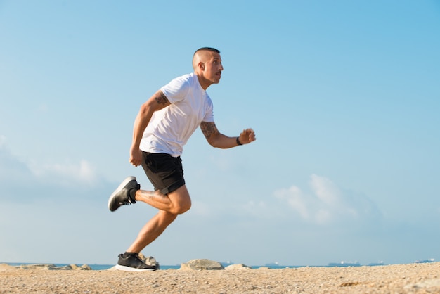 Determinado jovem atleta correndo na praia
