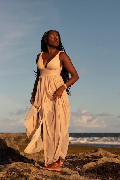 Foto grátis deusa grega de tiro completo posando na praia