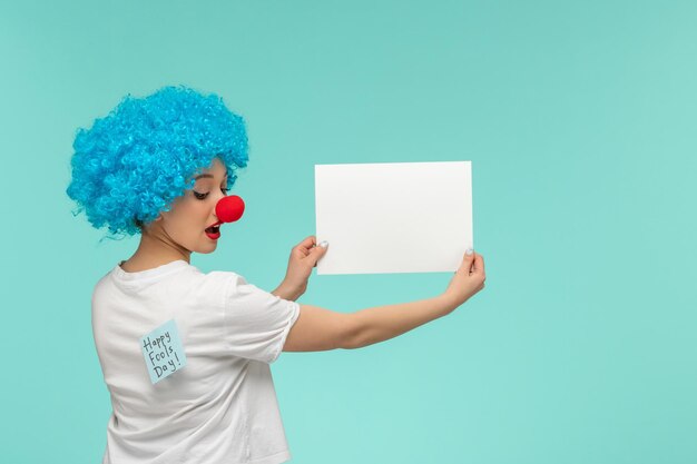 Dia da mentira, palhaço, nariz vermelho, segurando papel, olhando para azul, poste-o nas costas, cabelo azul