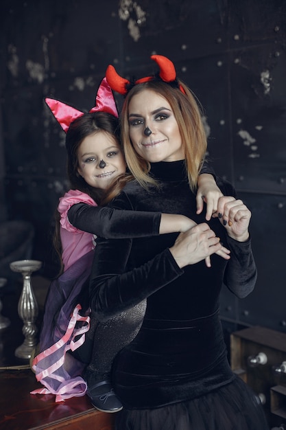 Dia das bruxas. mãe e filha com fantasia de halloween. família em casa.