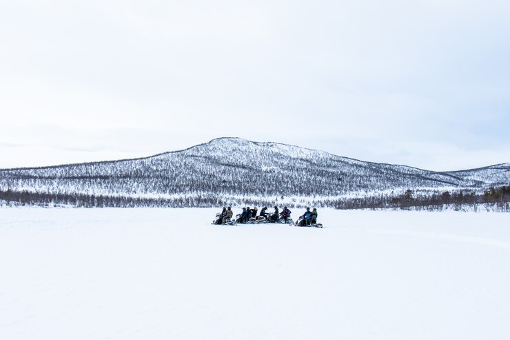 Foto grátis dia de neve com pessoas andando de snowmobiles ao longe no norte da suécia