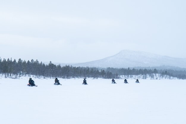 Dia de neve com pessoas andando de snowmobiles no norte da Suécia