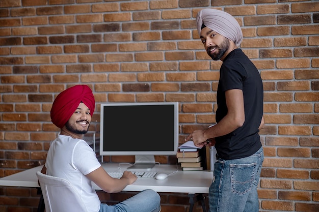 Foto grátis dia de trabalho. dois homens indianos trabalhando juntos e parecendo satisfeitos