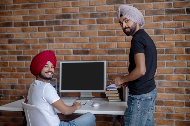 Dia de trabalho. Dois homens indianos trabalhando juntos e parecendo satisfeitos