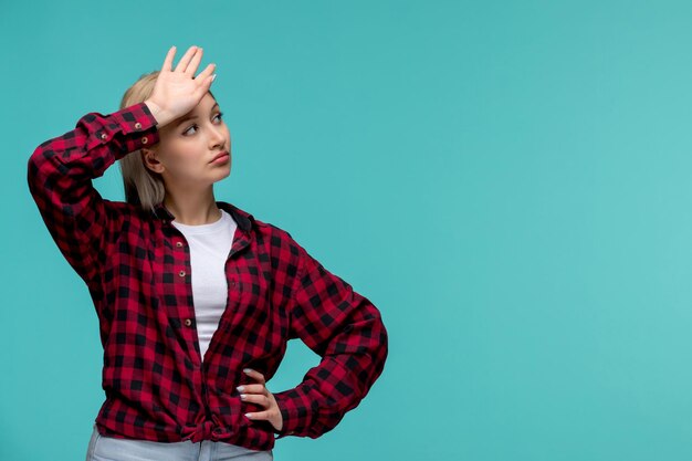 Foto grátis dia dos estudantes internacionais linda linda garota de camisa vermelha olhando para cima e tocando a testa