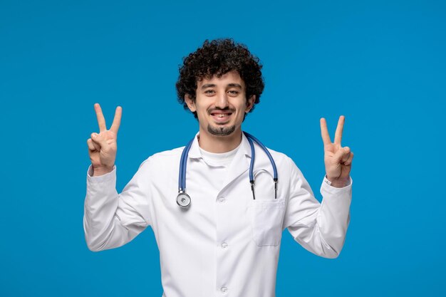 Dia dos médicos morena encaracolada bonitinha de jaleco mostrando gesto de paz