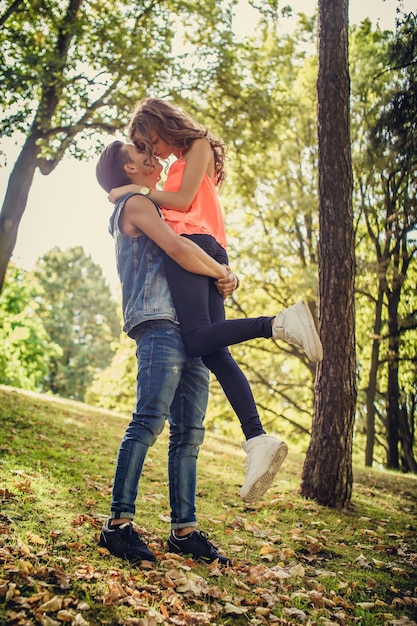 Dia dos namorados. Casal jovem casual. Um homem segurando uma garota nos braços no parque primavera.