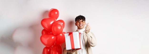 Dia dos namorados e conceito de romance jovem bonito mostrando presente surpresa para amante e dedo hea