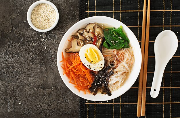 Dieta tigela vegetariana de sopa de macarrão de cogumelos shiitake, cenoura e ovos cozidos. Comida japonesa Vista do topo. Configuração plana