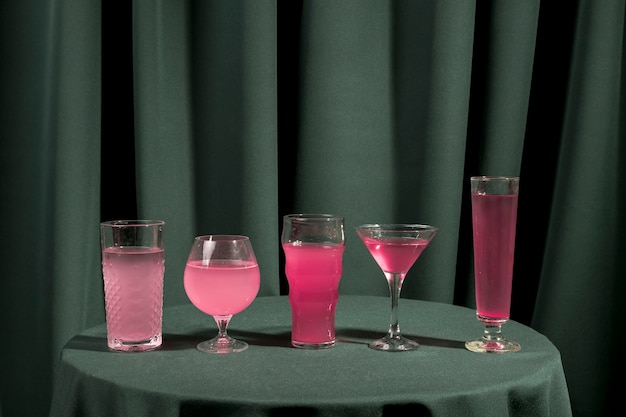 Foto grátis diferentes copos cheios de líquido rosa na mesa