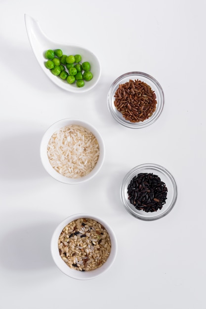 Foto grátis diferentes tipos de arroz com feijão verde em taças na mesa