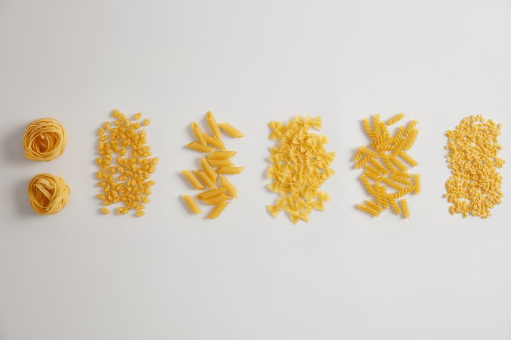 Foto grátis diferentes tipos de massa crua crua no fundo branco. ninhos de macarrão, farfalle, tripolini, penne, fusilli podem ser usados para molhos ou pratos. variedade de produtos italianos. várias formas. conceito de comida