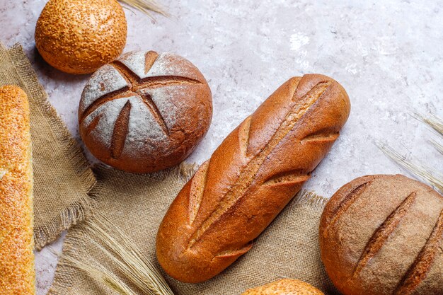 Diferentes tipos de pão fresco como pano de fundo, vista superior