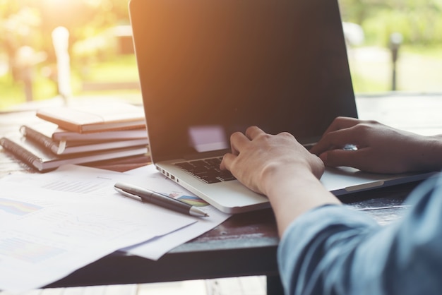 Digitação mão da mulher de negócios no teclado do portátil com cha financeiro