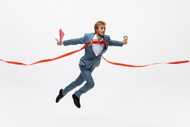 Digitando. homem com roupa de escritório correndo, correndo no espaço em branco como atleta profissional, esportista. invulgar procura empresário em movimento, ação com bola. esporte, estilo de vida saudável, criatividade.