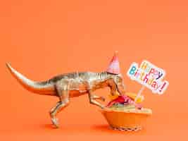 Foto grátis dinossauro de brinquedo comendo doces de aniversário