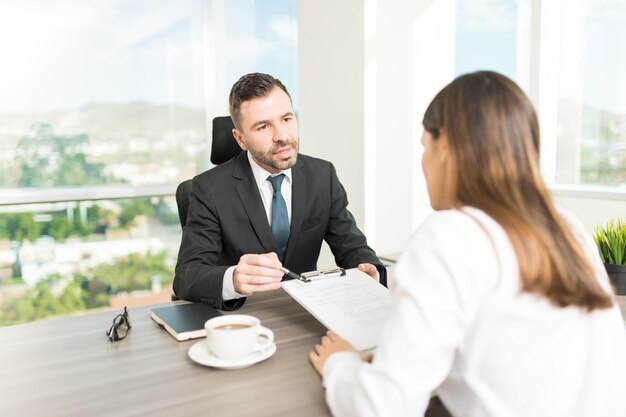 Diretor da empresa explicando os termos do contrato ao novo funcionário no cargo