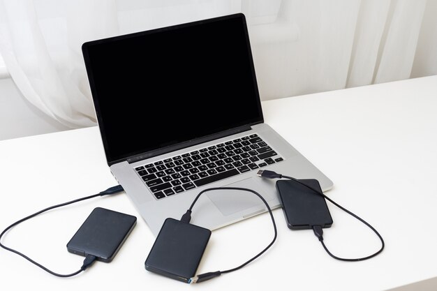 Disco rígido de backup externo conectado ao laptop. foto de alta qualidade
