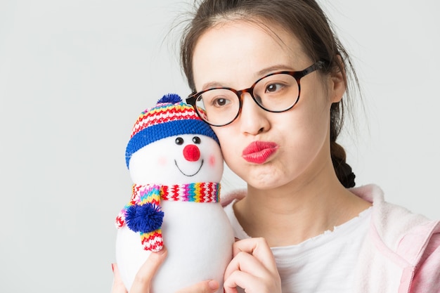 Disparado no estúdio da jovem asiática segurando um boneco de neve de Natal