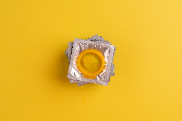 Disposição de preservativos amarelos de vista superior