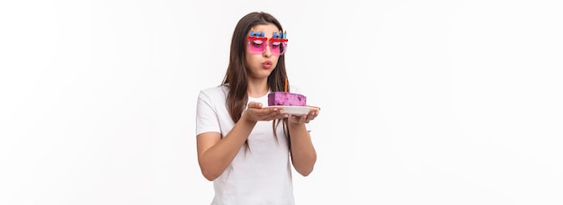 Foto grátis diversão de entretenimento e retrato do conceito de férias de uma linda e engraçada aniversariante soprando a vela o