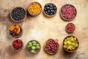 Foto grátis diversas frutas naturais e frescas em pequenos potes de madeira marrom