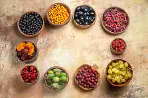 Foto grátis diversas frutas naturais e frescas em pequenos potes de madeira marrom