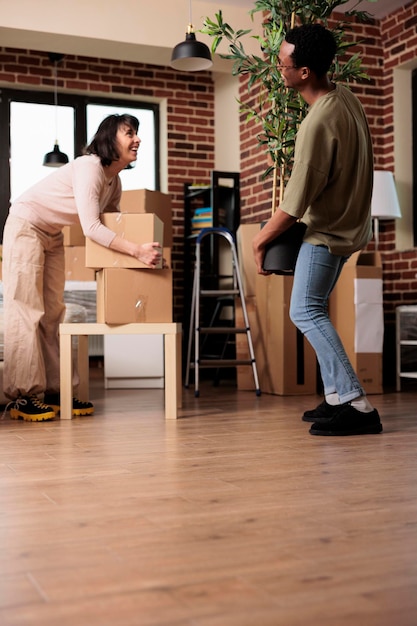 Foto grátis diversas pessoas comprando o primeiro apartamento e indo morar juntas, desempacotando plantas e móveis para decorar a casa. aproveitando a realocação de propriedade com decoração para iniciar novos começos de vida.