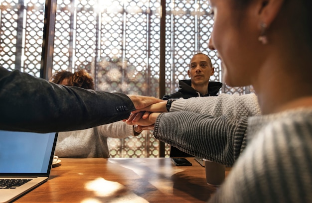 Diversas pessoas empilhando as mãos juntas