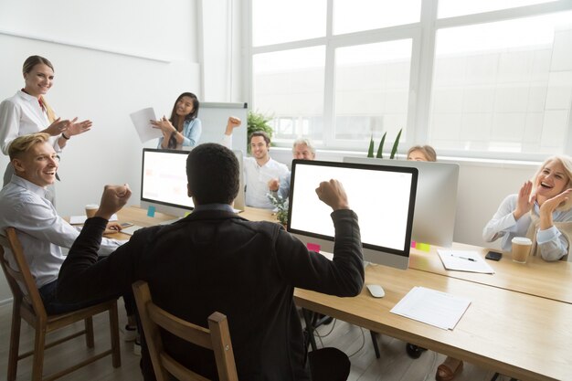 Diversos colegas parabenizando colega de trabalho negra com bom resultado ou ganhar