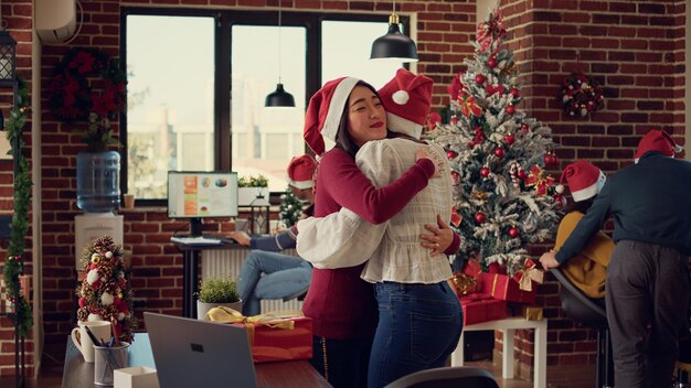 Diversos colegas trocando presentes na festividade de inverno no escritório de inicialização, dando presentes para comemorar a véspera de natal. Sentindo-se feliz na celebração sazonal com luzes e decorações de Natal.