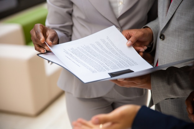 Diversos parceiros de negócios lendo contrato juntos