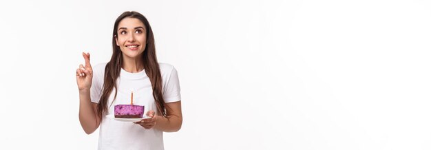 Foto grátis divertimento do entretenimento e retrato do conceito dos feriados do sorriso positivo da jovem desejável cruzar o dedo