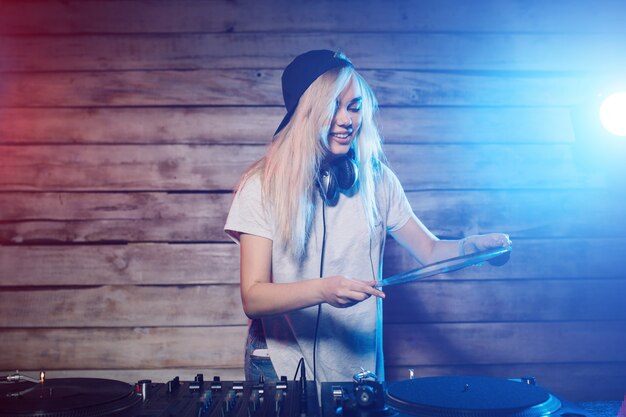 Dj bonito mulher se divertindo tocando música na festa do clube