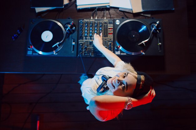 Dj bonito mulher se divertindo tocando música na festa do clube