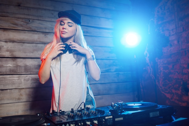 Dj bonito mulher se divertindo tocando música na festa do clube