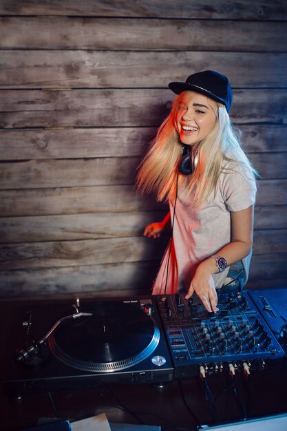 Dj bonito mulher se divertindo tocando música na festa do clube