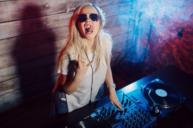 Dj bonito mulher se divertindo tocando música na festa do clube