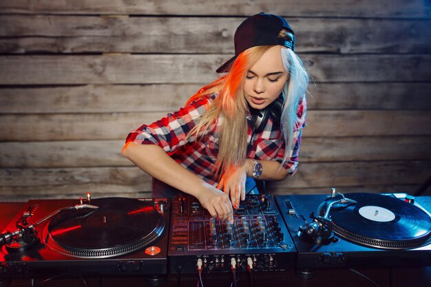 Dj bonito mulher se divertindo tocando música na festa do clube