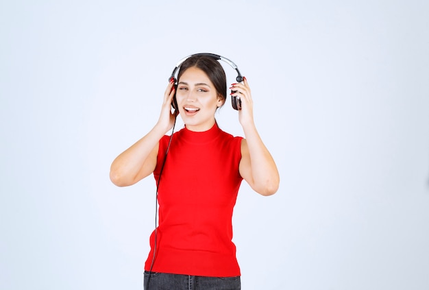 Dj com fones de ouvido tirando um ouvido para ouvir bem.